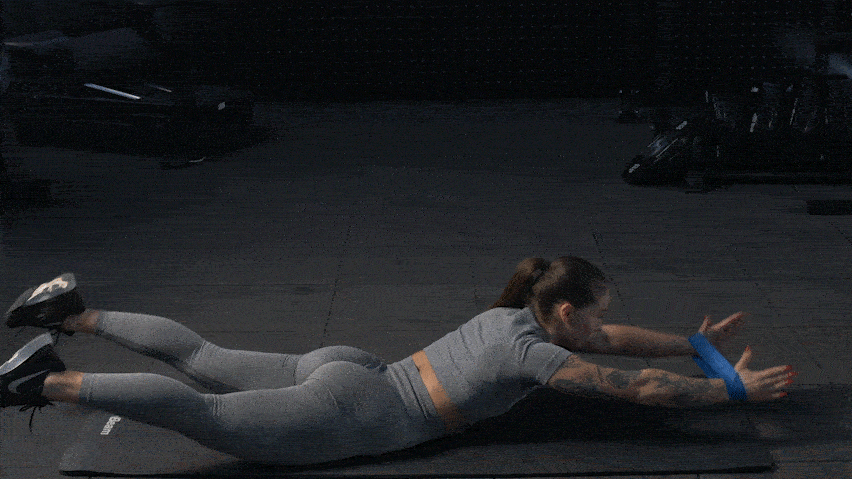 Вправа на обертання лежачи з еспандером